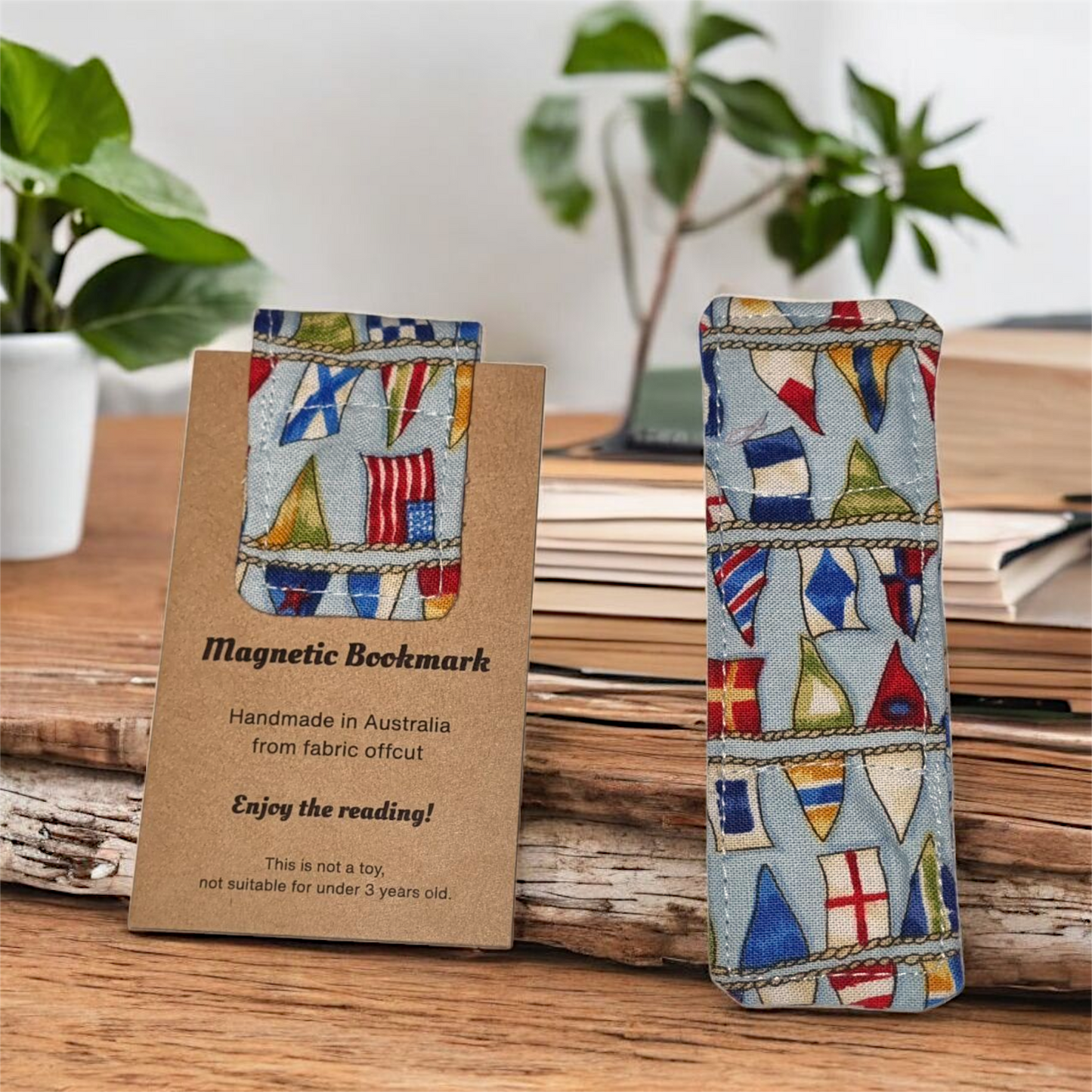 Magnetic bookmark with Different countries flag design on a wooden surface with plants in the background