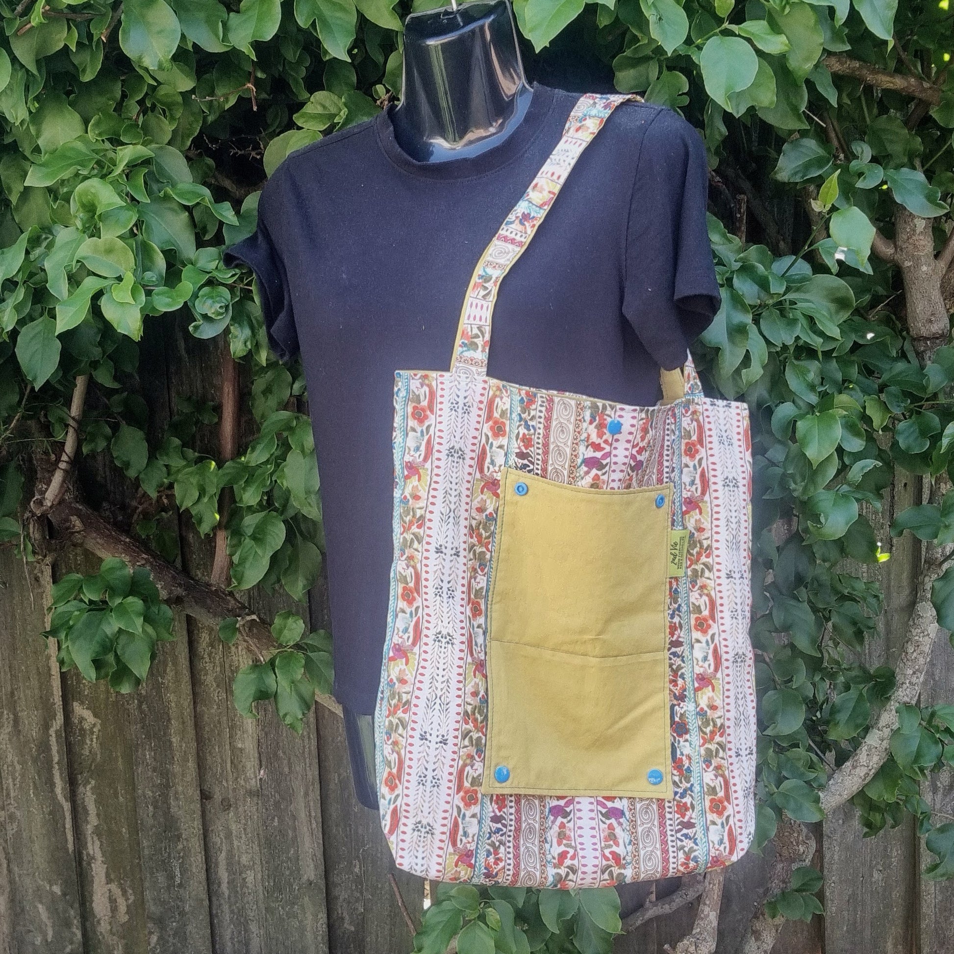 Durable reusable tote bag in multicolour tapestry stripe print with mustard yellow pocket.