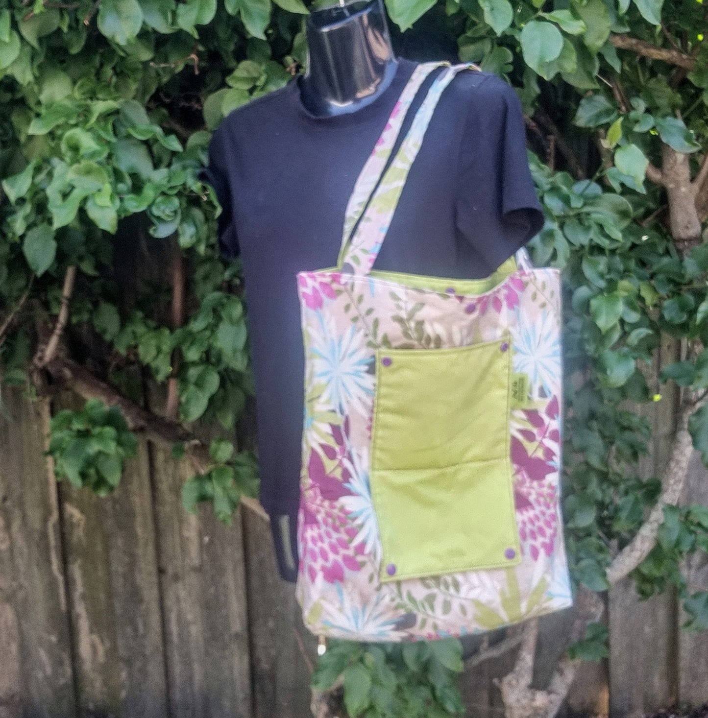 Reusable tote bag in vibrant tropical floral pattern with green pocket.