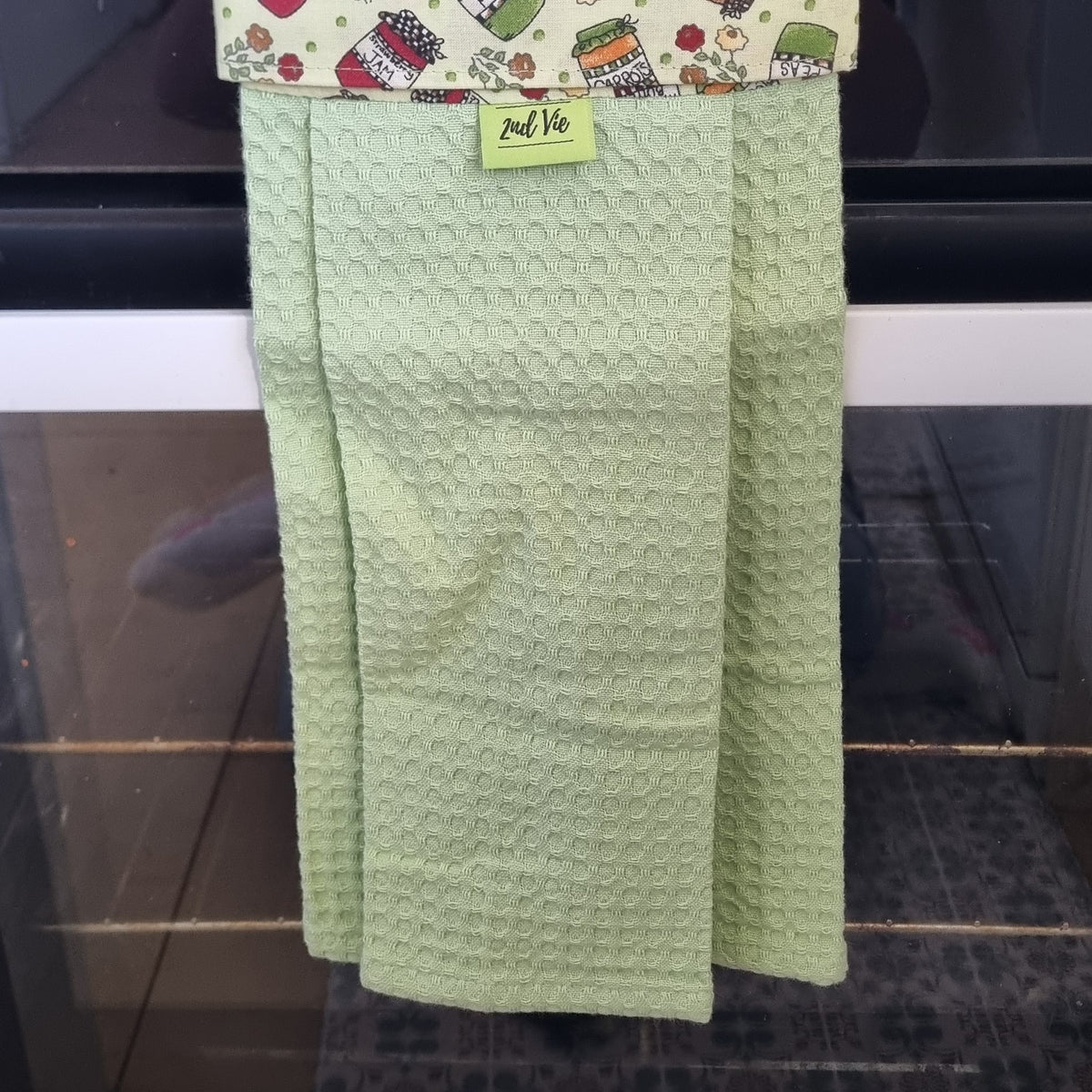 Pantry Jars hanging tea towel with mint green waffle fabric on an oven handle
