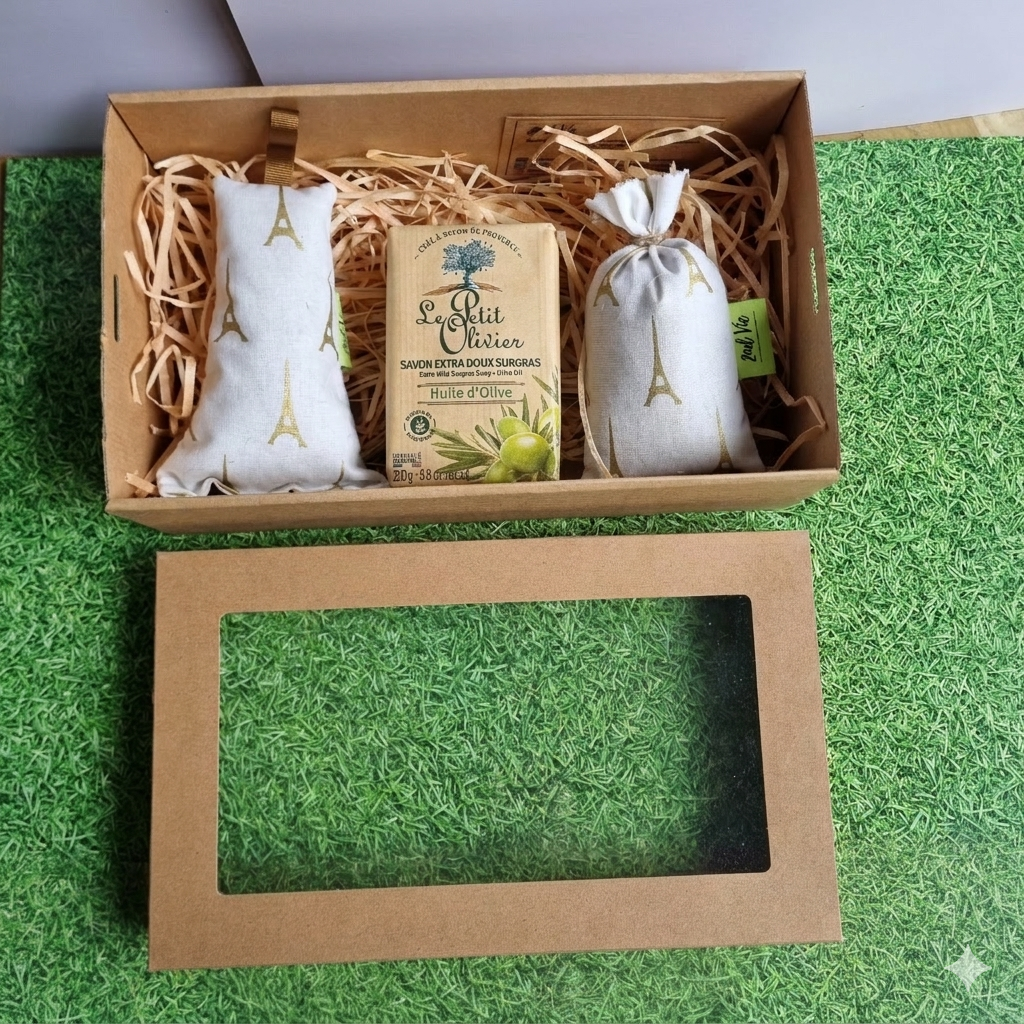 Gift box with a product labeled 'L'Art du Savon' on a green grass-like surface.