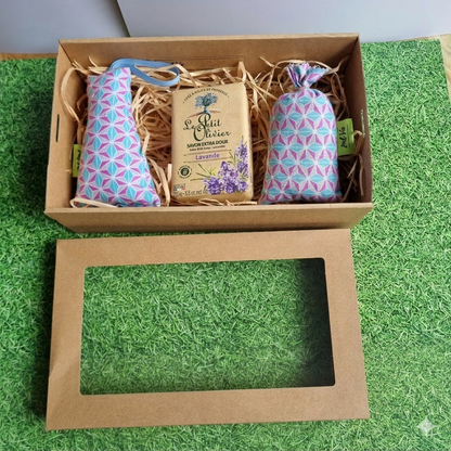 Gift set with lavender sachets and packaging on a green grass-like surface