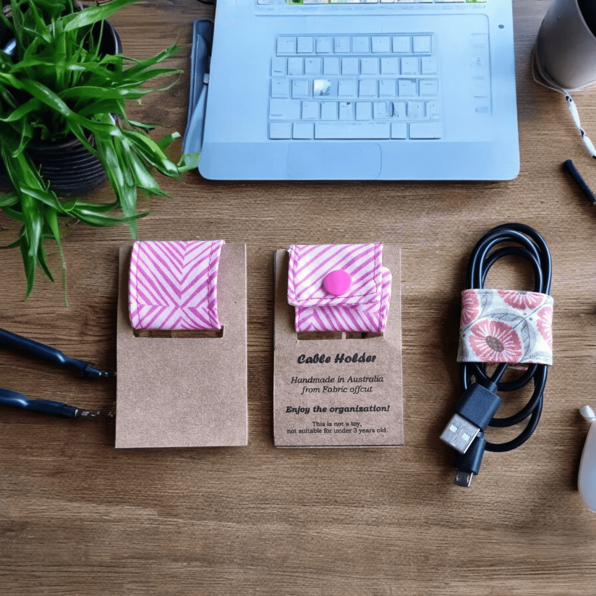 "Pink Lines Cable Holder Organiser holding USB cables on des