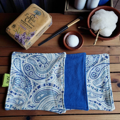 Eco-friendly makeup remover pads featuring elegant blue paisley design, displayed with artisan soap and natural cotton in wooden bowls