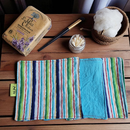 Reusable makeup remover pads with vibrant rainbow stripe pattern in blue, green, red, and yellow, styled with natural lavender soap and cotton