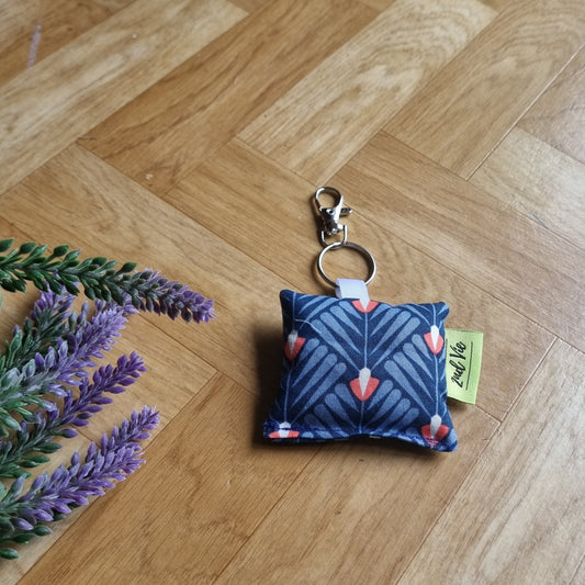 Fabric keychain with geometrical  floral pattern on a wooden floor with lavender flowers