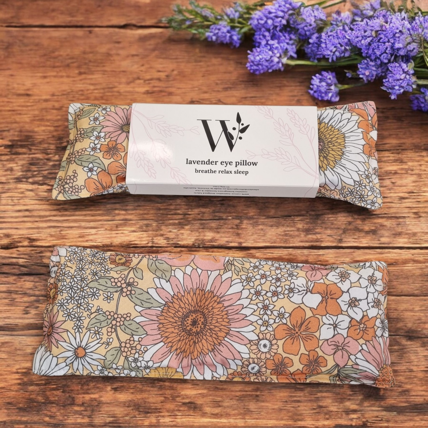 Daisy Floral-patterned lavender eye pillow with packaging on a wooden surface
