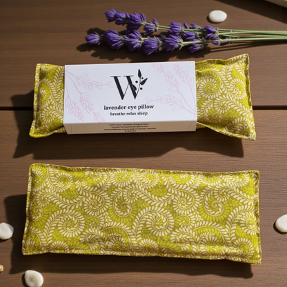 Two fern pattern  lavender eye pillows  with a packaging card on a wooden surface.