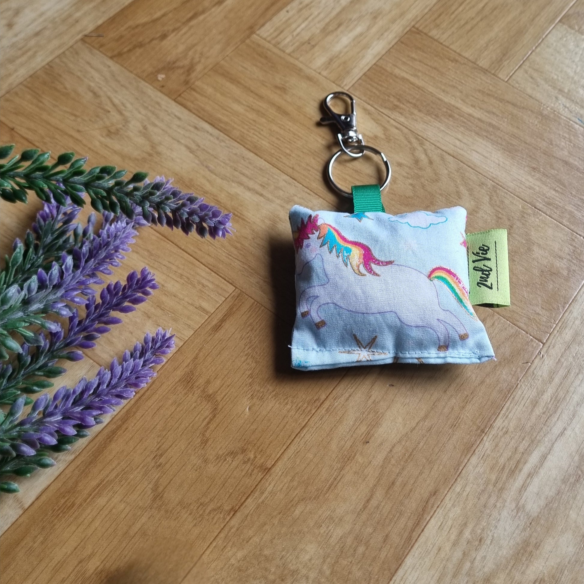 Keychain with unicorn design on a wooden floor with lavender flowers