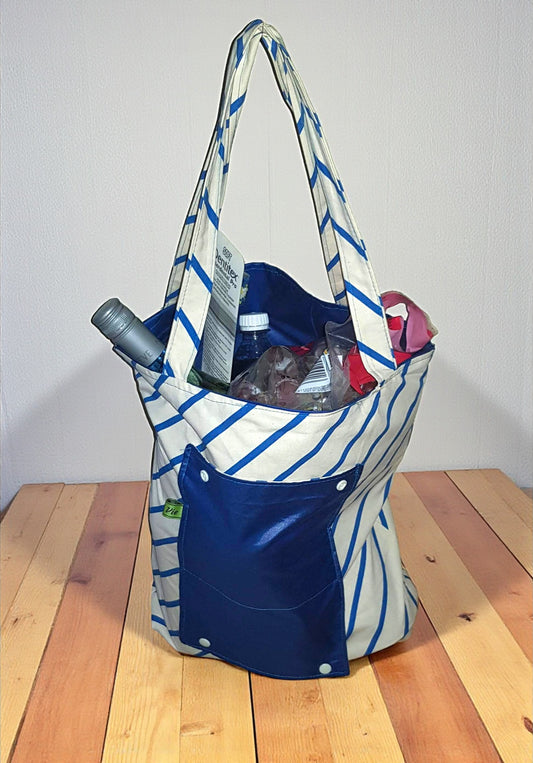 Striped tote bag filled with groceries on a wooden surface